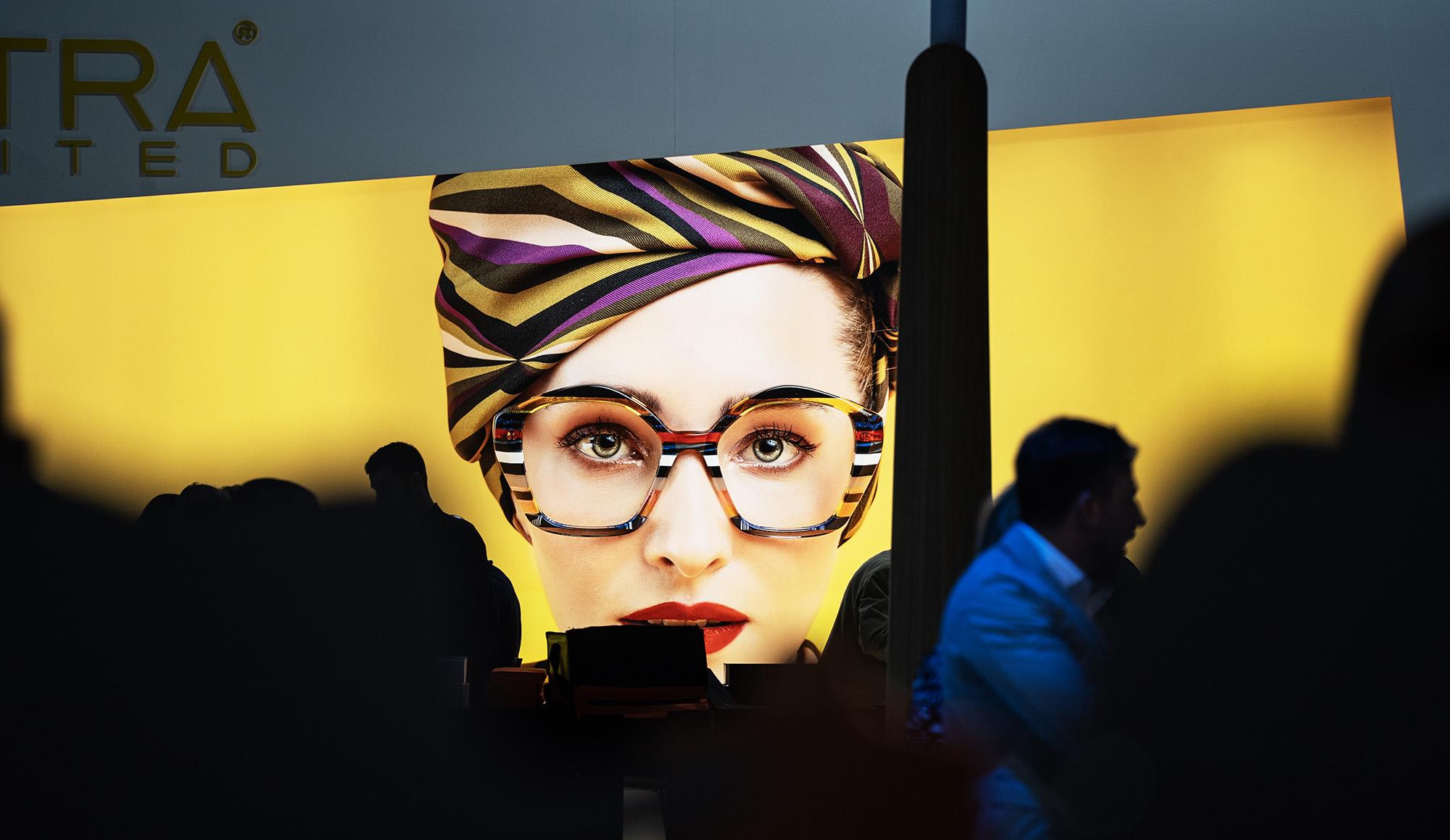 Bild einer Frau mit bunter Brille auf einem großen Poster